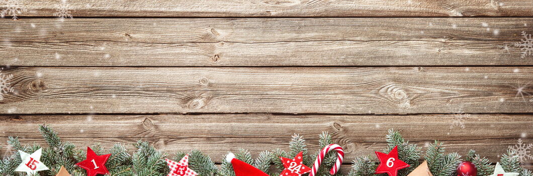 Tannenzweige auf Holzuntergrund mit Sternen und Geschenken